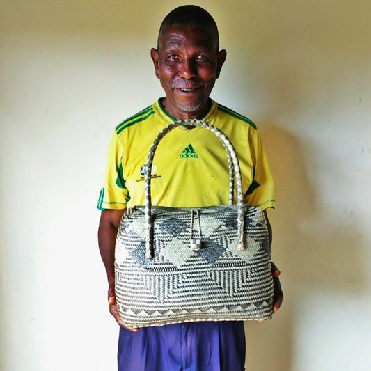 Master artisan Abel holding one of his unique woven basket bags